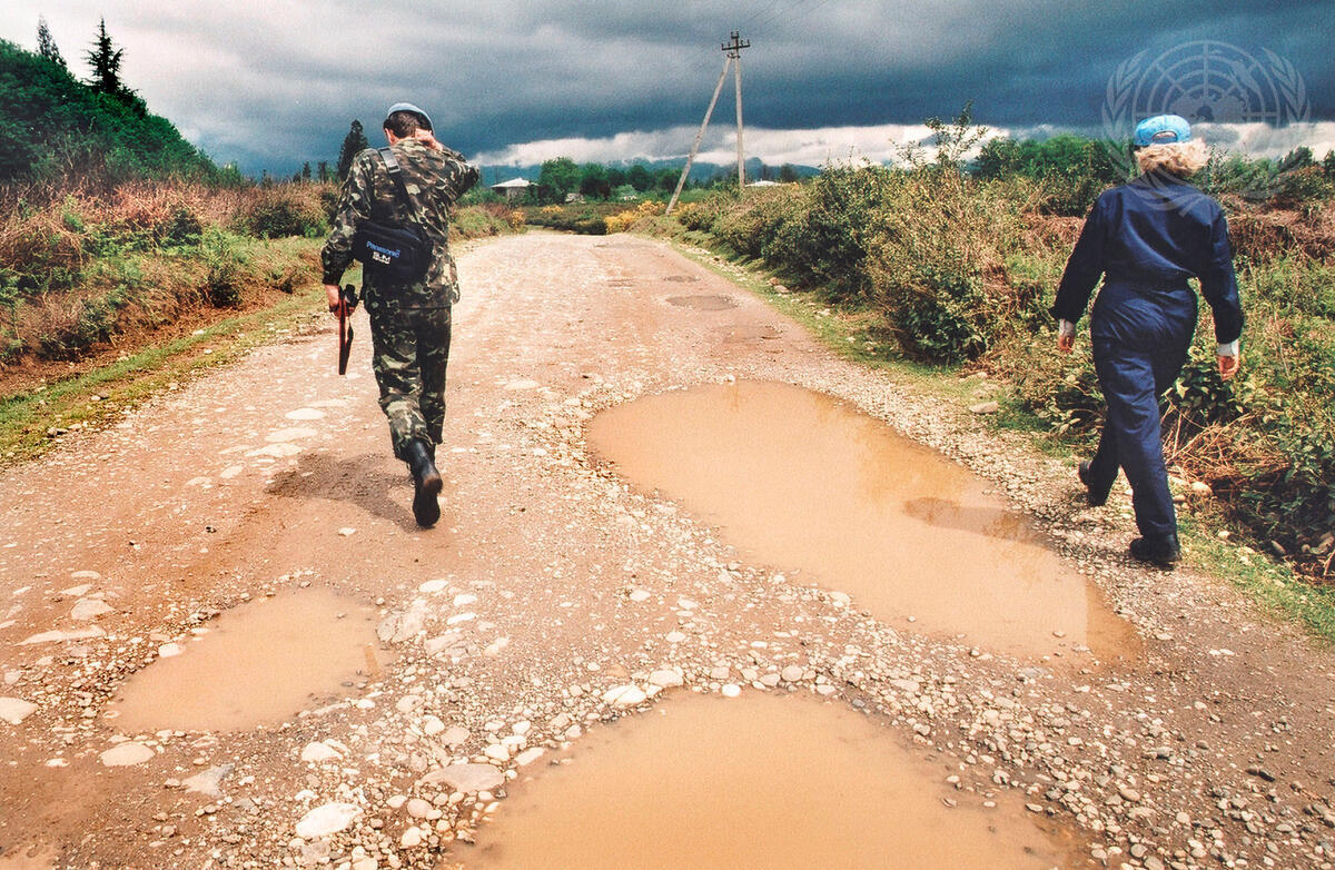 Two official looking persons walking in a dirt road